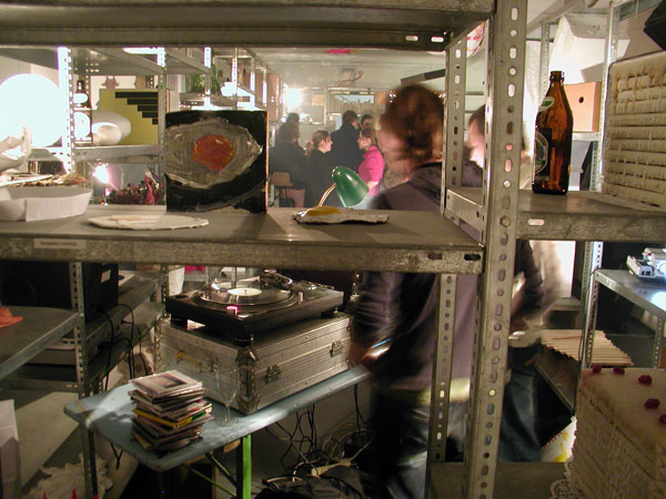 Regal mit Spiegelei und DJs dahinter